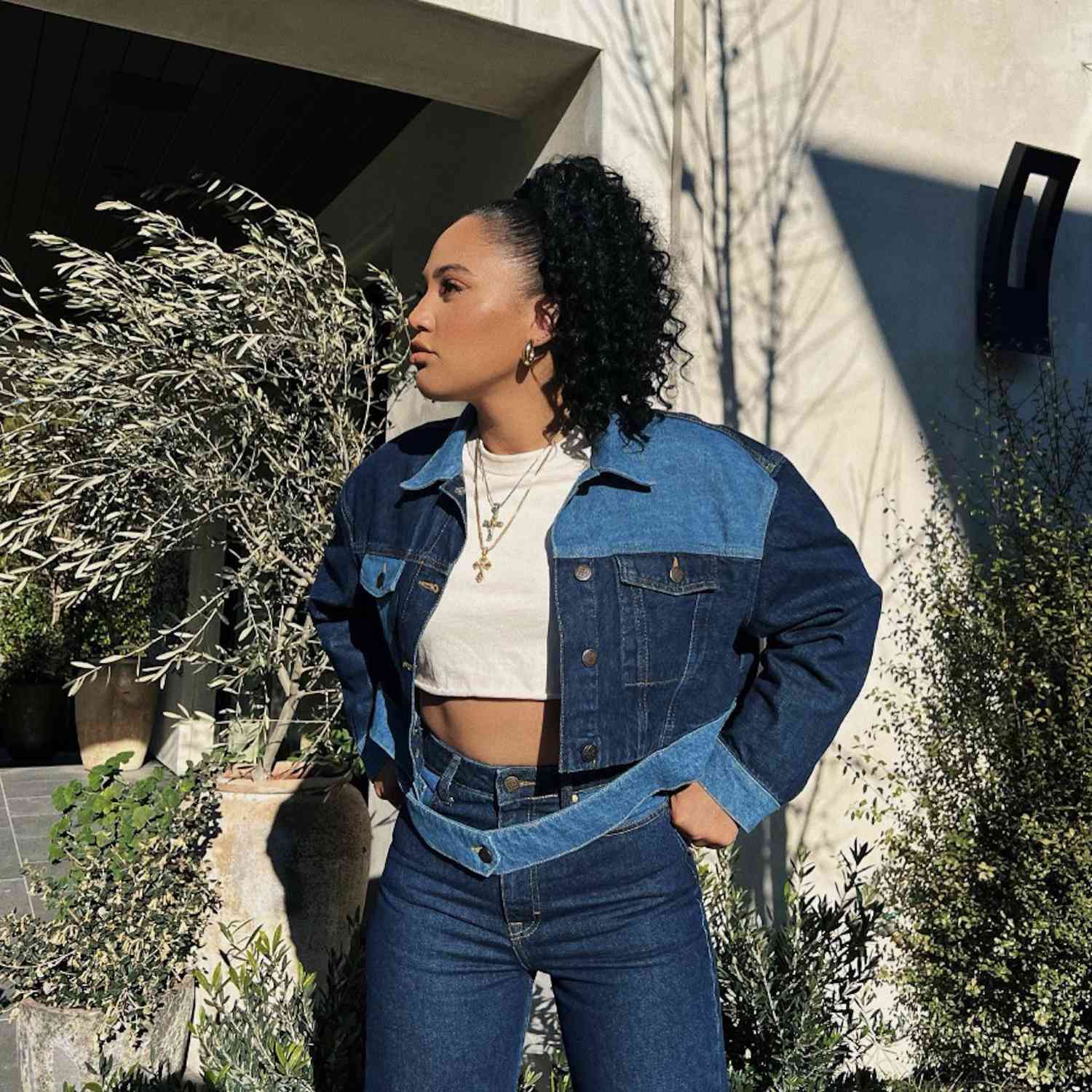 Ayesha Curry outdoors wearing a sleek on top curly ponytail